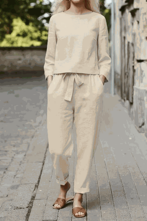 Woman wearing beige cotton-linen monochrome relaxed longline top and wide-leg pants set outdoors