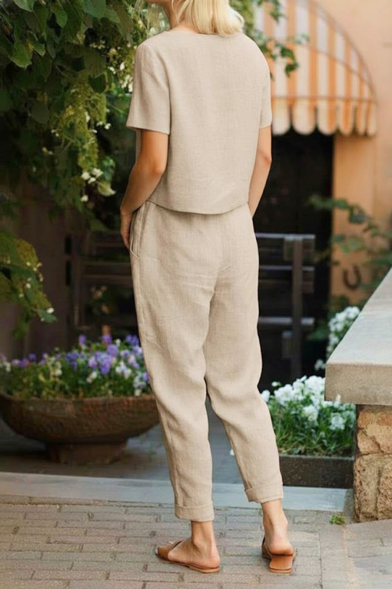 Woman wearing beige cotton linen set with short sleeves and straight-leg pants outdoors