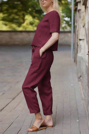 woman wearing relaxed fit burgundy cotton linen set with short-sleeve top and straight-leg pants outdoors