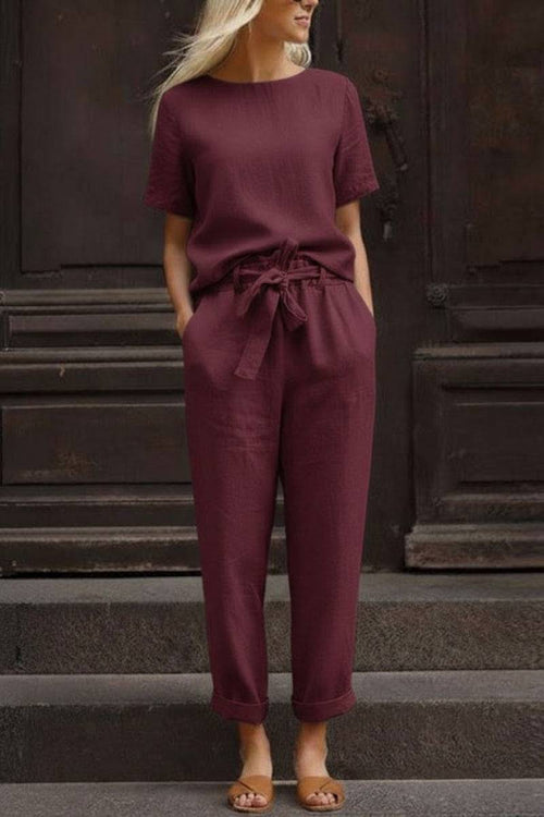 Woman wearing relaxed fit cotton linen set with short-sleeve top and straight-leg pants in maroon color