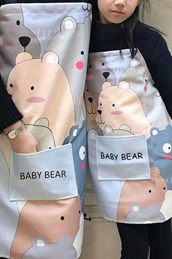 Matching Mommy & Me Apron Set with cartoon bear pattern and front pockets, oil-proof cotton linen material for kids and adults.