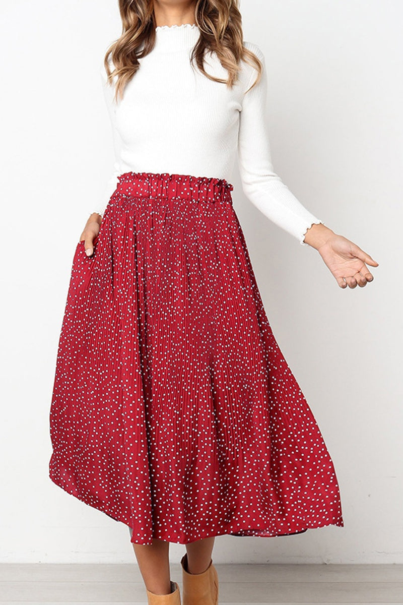 woman wearing effortlessly chic polka dot pleated red midi skirt with pockets and white long sleeve top