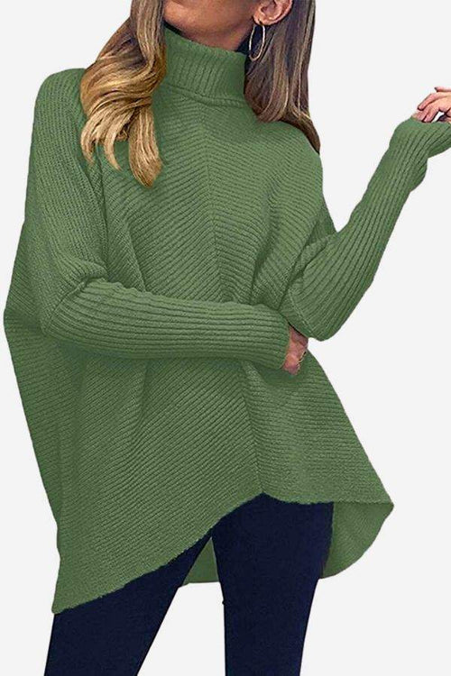 Green cozy oversized knit pullover with high neck and long sleeves, styled with dark pants
