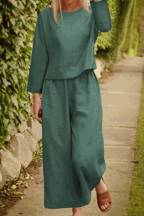 Woman wearing loose solid color two-piece set with long sleeves and wide-leg pants outdoors
