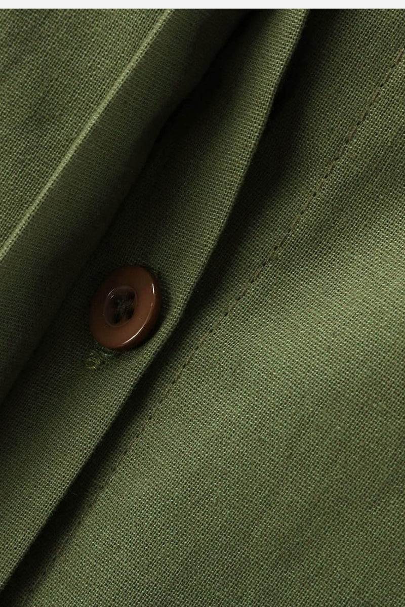 Close-up of olive green relaxed shirt and trousers set fabric with brown button detail