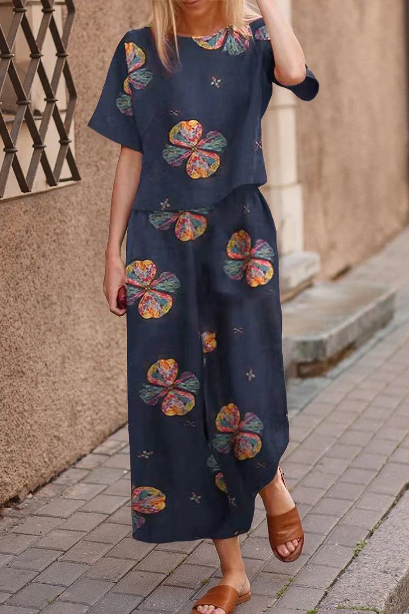 Woman wearing navy blue loose fit co-ord set with colorful floral prints and wide-leg pants on street