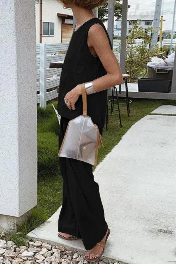 Loose solid color sleeveless two-piece set with oversized fit and wide-leg pants in black worn outdoors
