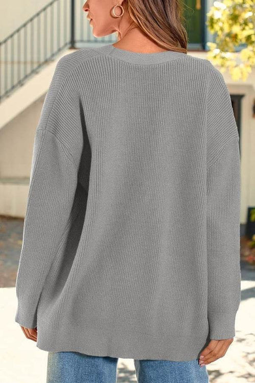 Back view of a woman wearing a gray relaxed fit oversized knitwear cardigan outdoors