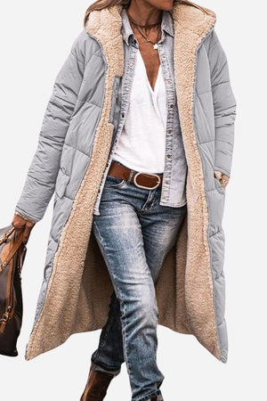 Long grey Sherpa-lined hooded teddy coat with plush interior, durable puffer exterior, and big pockets, styled with casual outfit.