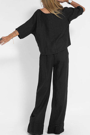 Woman wearing black short-sleeved pullover and wide trouser matching set from back view