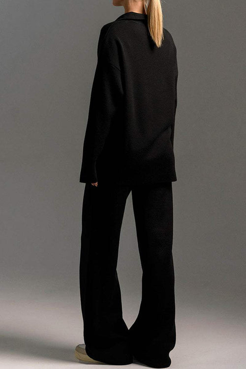 Back view of a model wearing black Plush & Preppy Camel Two-Piece Set with wide-leg pants and long-sleeve pullover against a gray background