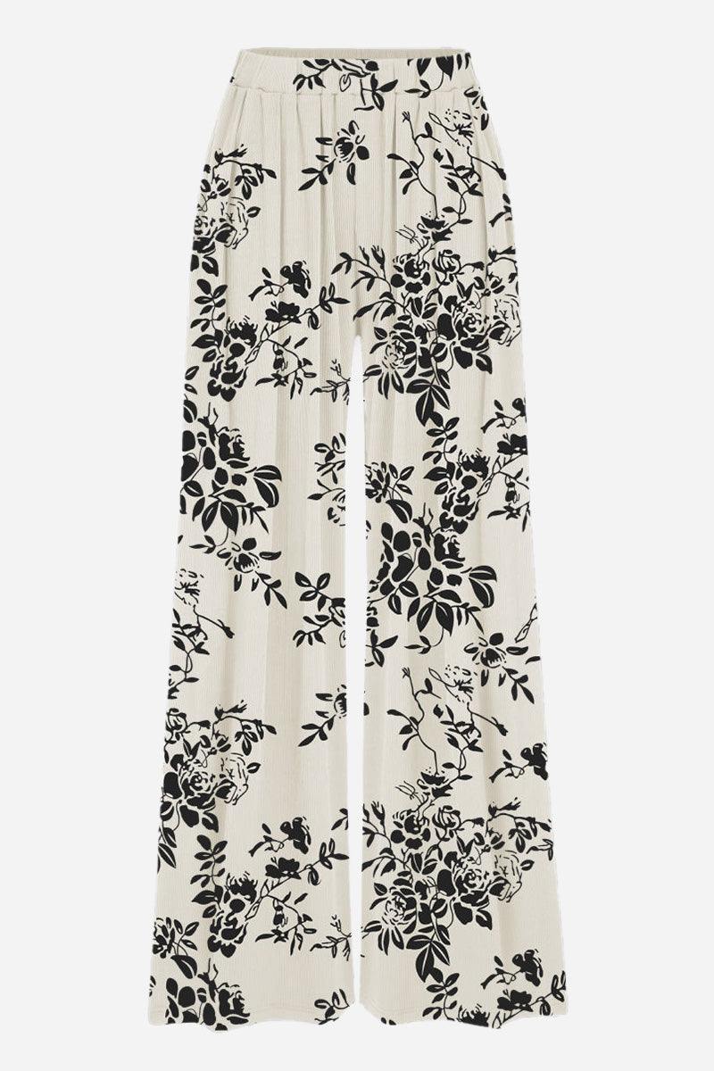 Stretchy wide-leg pants with black floral print on white fabric and elastic waistband for all-day comfort