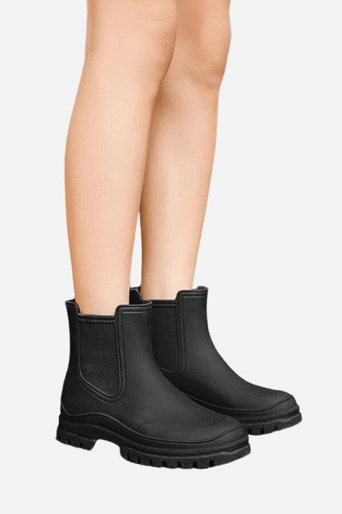 Black non-slip rain boots with SuperGrip soles on model's legs