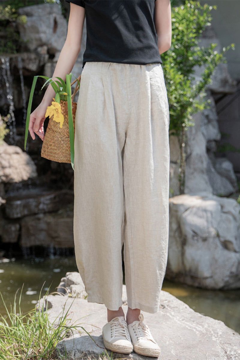 Woman wearing beige Ramie Linen Cotton Pants with relaxed fit outdoors near rocks and greenery