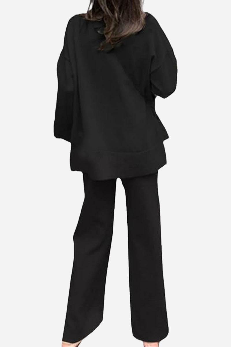 Woman wearing black knitted turtleneck two-piece set with loose top and wide-leg pants back view