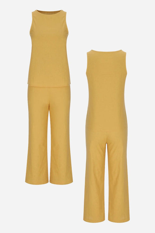 Sleek silhouette coordinated set with sleeveless top and wide-leg pants in mustard yellow, made from stretchy polyester-spandex blend for comfortable, wrinkle-resistant wear.