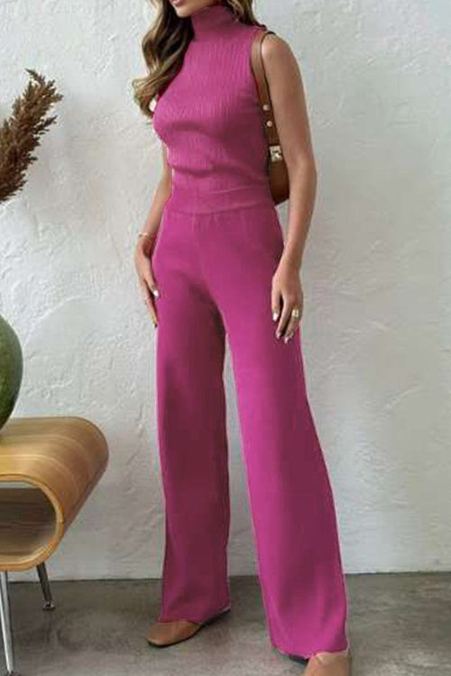 Woman wearing elegant magenta sleeveless top and matching wide-leg pants from a three-piece collection