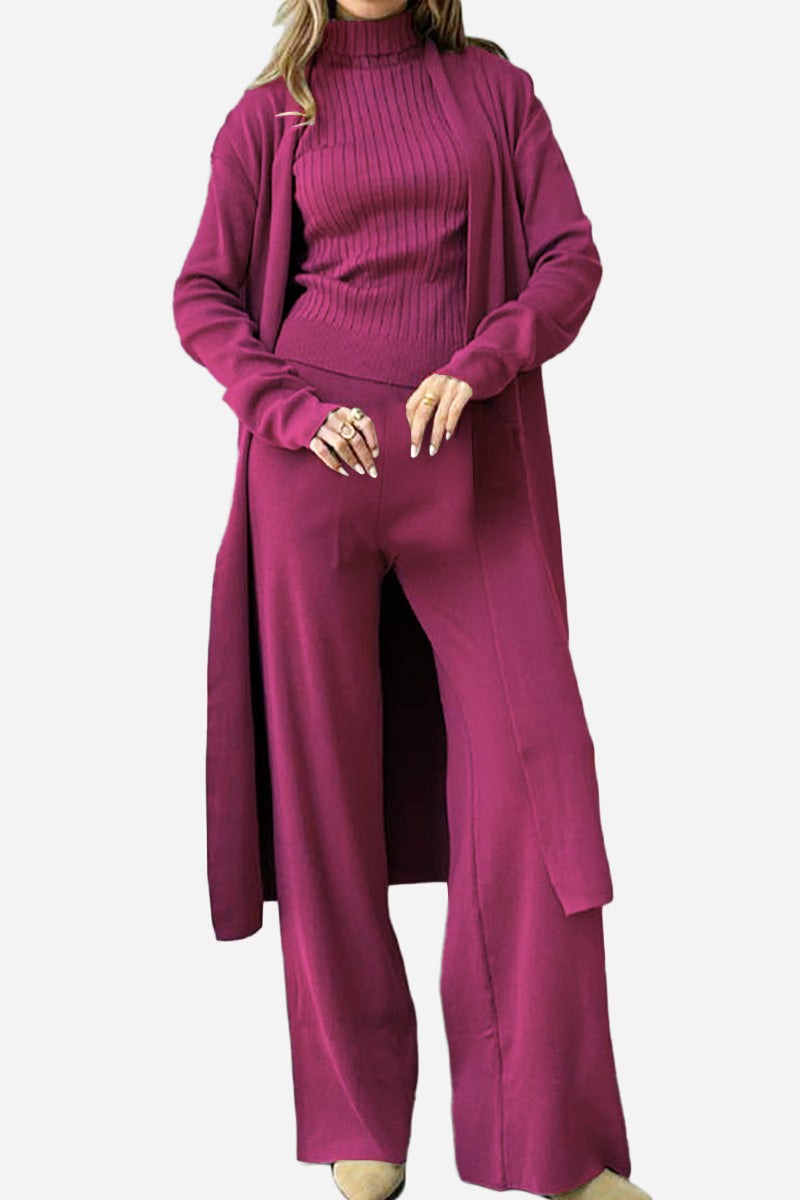 Woman wearing a one size fits all premium three-piece collection in burgundy, featuring a turtleneck top, wide-leg pants, and long cardigan.