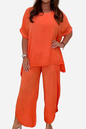 Relaxed linen-like travel 2-piece set in bright orange with loose-fitting top and wide-leg pants for comfortable, wrinkle-resistant style.