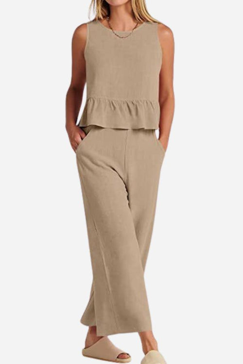 Woman wearing beige linen-like feel set with sleeveless peplum top and wide-leg pants