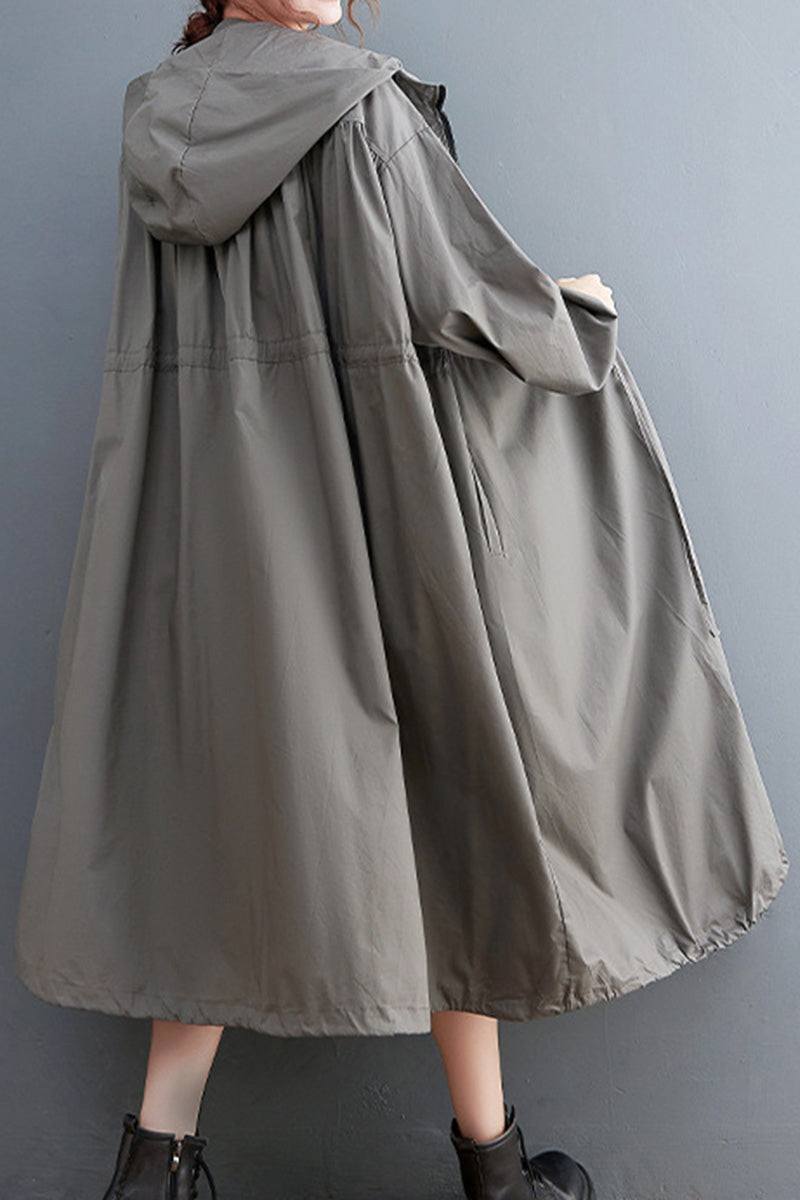 Oversized all-weather water-resistant windbreaker with hood, in neutral gray, worn over casual outfit.