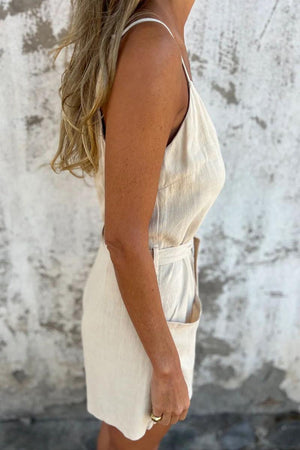 Side view of woman wearing 100% pure linen breathable natural comfort jumpsuit with adjustable waist tie and pockets
