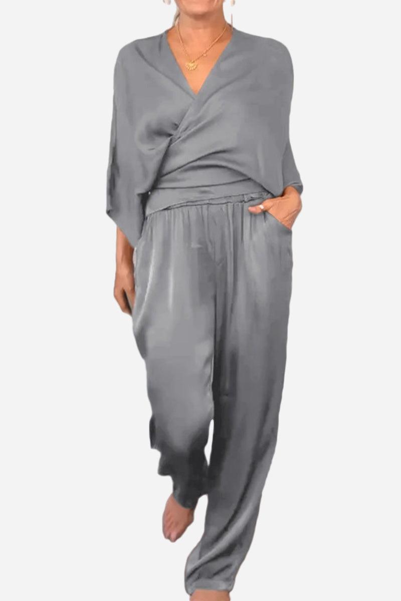 woman wearing light grey satin wrap lounge two-piece set with V-neck top and relaxed pants