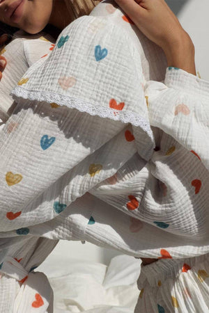 Close-up of Sweet Countryside 100 Cotton white ruffled two-piece set with colorful heart prints and lace trim sleeve detail
