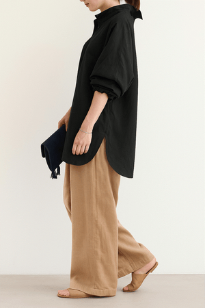 Woman wearing Linen Breeze Set with black oversized shirt and beige high-waist linen-cotton blend pants