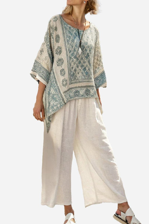 Woman wearing Santorini Sunset Striped two-piece set with patterned top and loose white pants