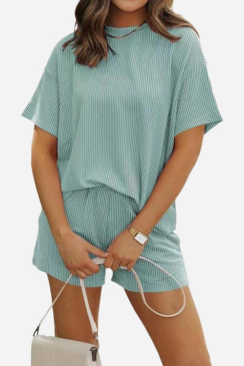 Woman wearing a comfortable ribbed short-sleeve top and matching shorts set for slow mornings in soft green polyester fabric