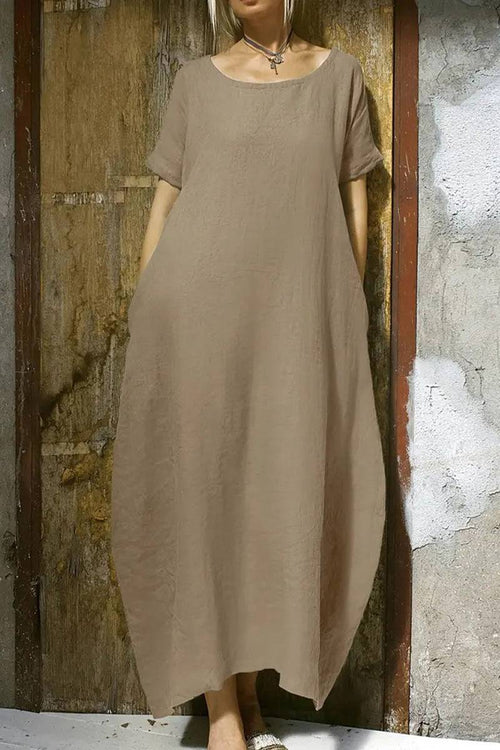 Breeze Cocoon Dress in beige linen-like fabric with rolled sleeves and relaxed airy silhouette.