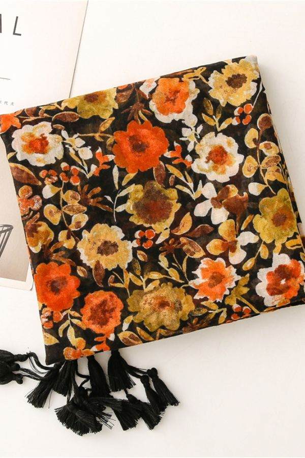 Twilight Blooms Scarf featuring warm floral print with tassel edges, lightweight polyester fabric.