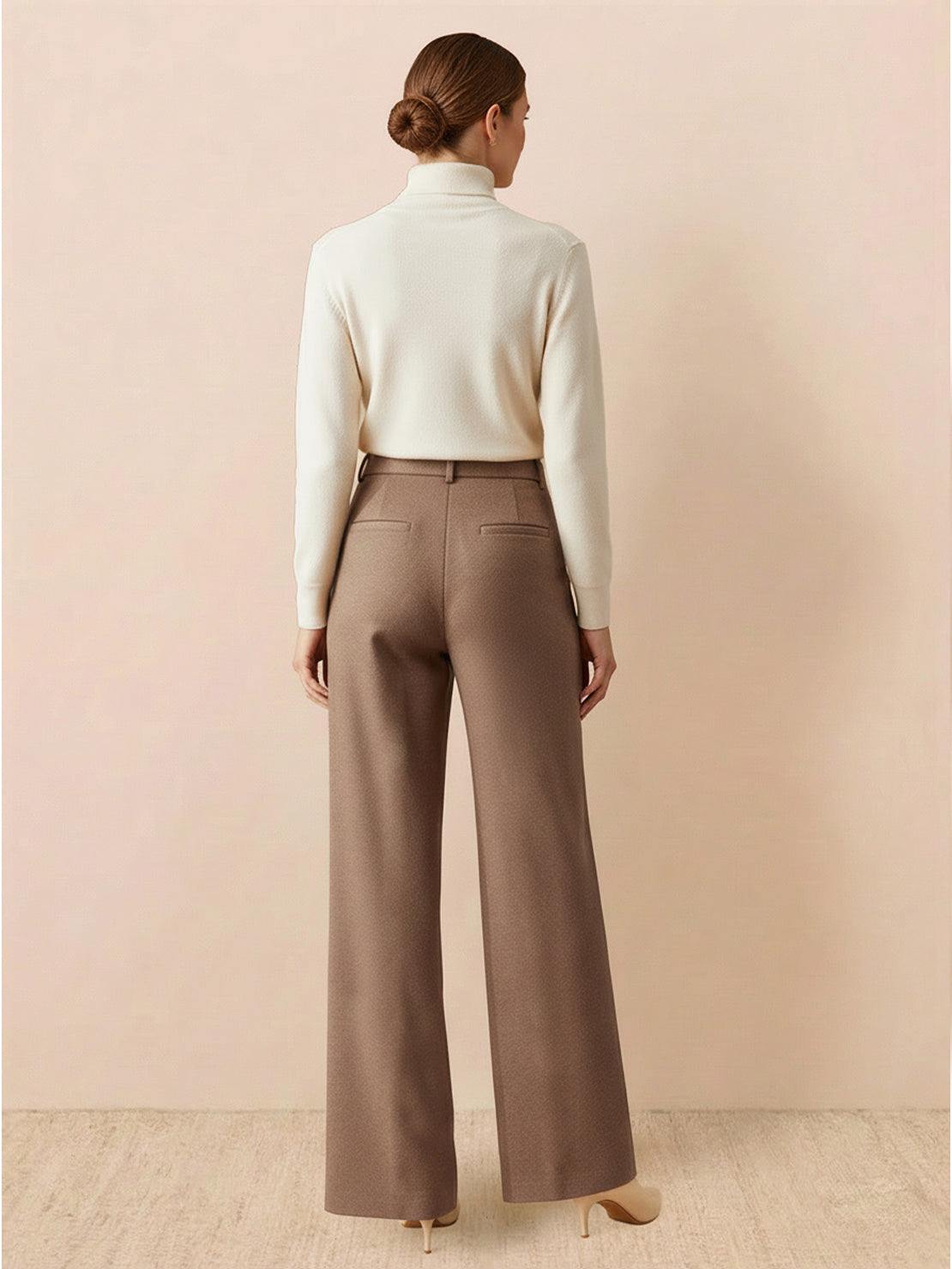 Woman wearing brown thermal wool blend trousers with wide-leg cut and elastic back waist, paired with a white turtleneck sweater.