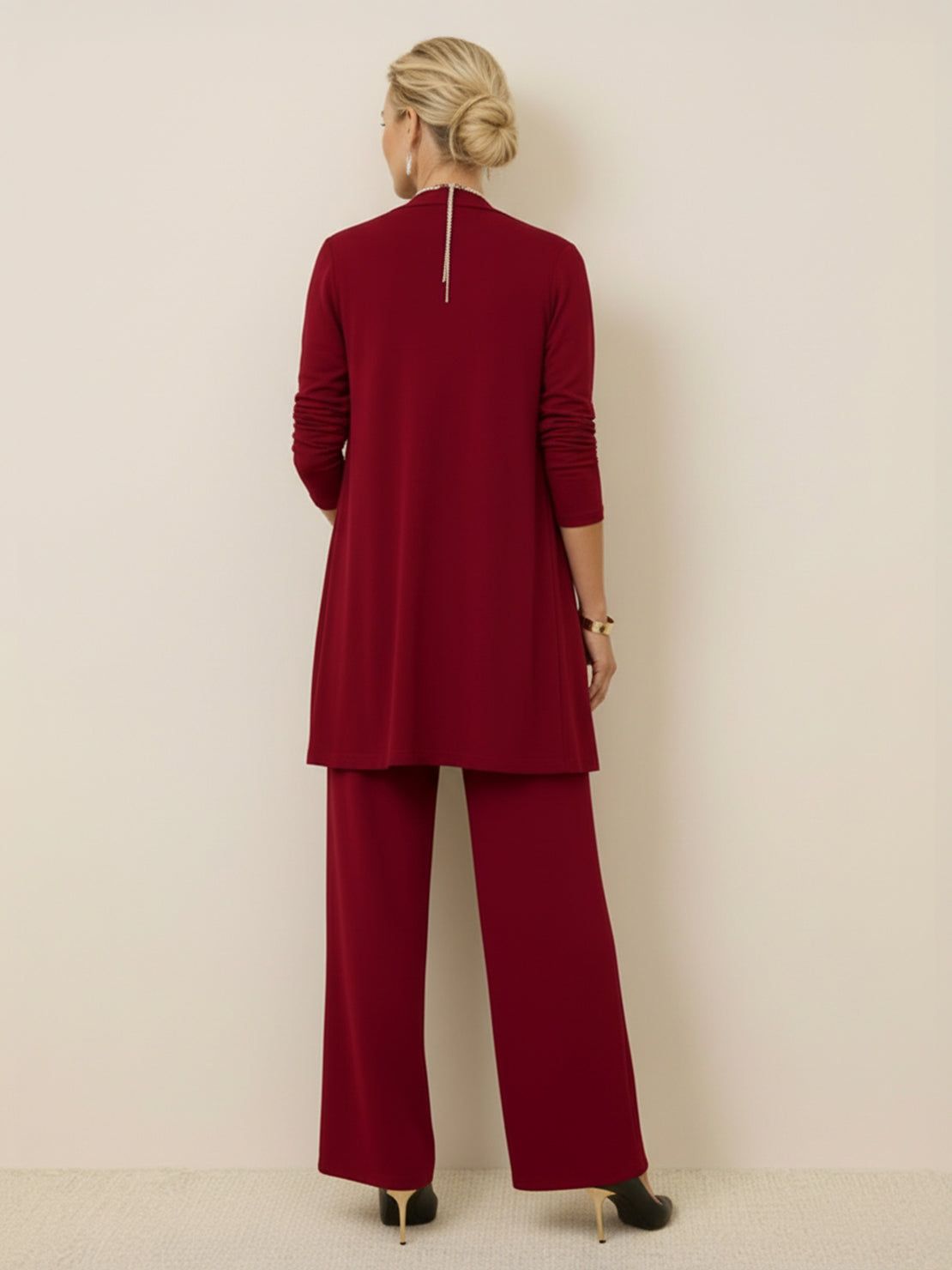 Woman wearing open-front longline cardigan, tank top, and wide-leg trousers three-piece co-ord set in lightweight knit fabric