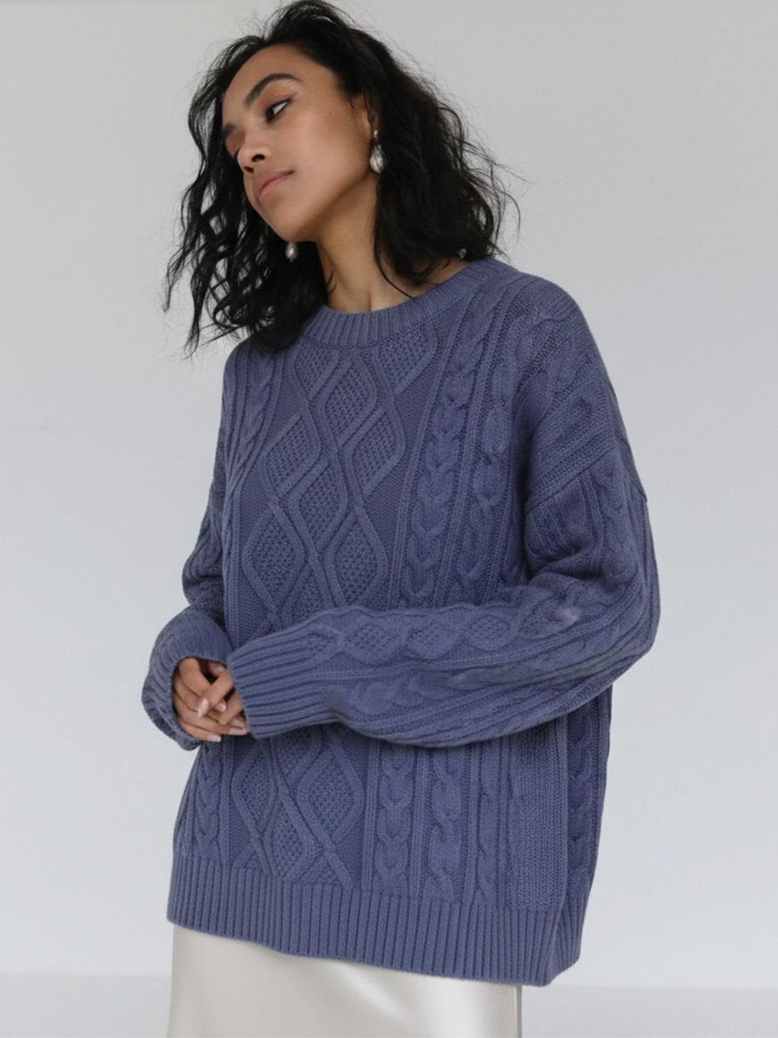 Oversized cable-knit crewneck sweater with dropped shoulders and thick textured fabric