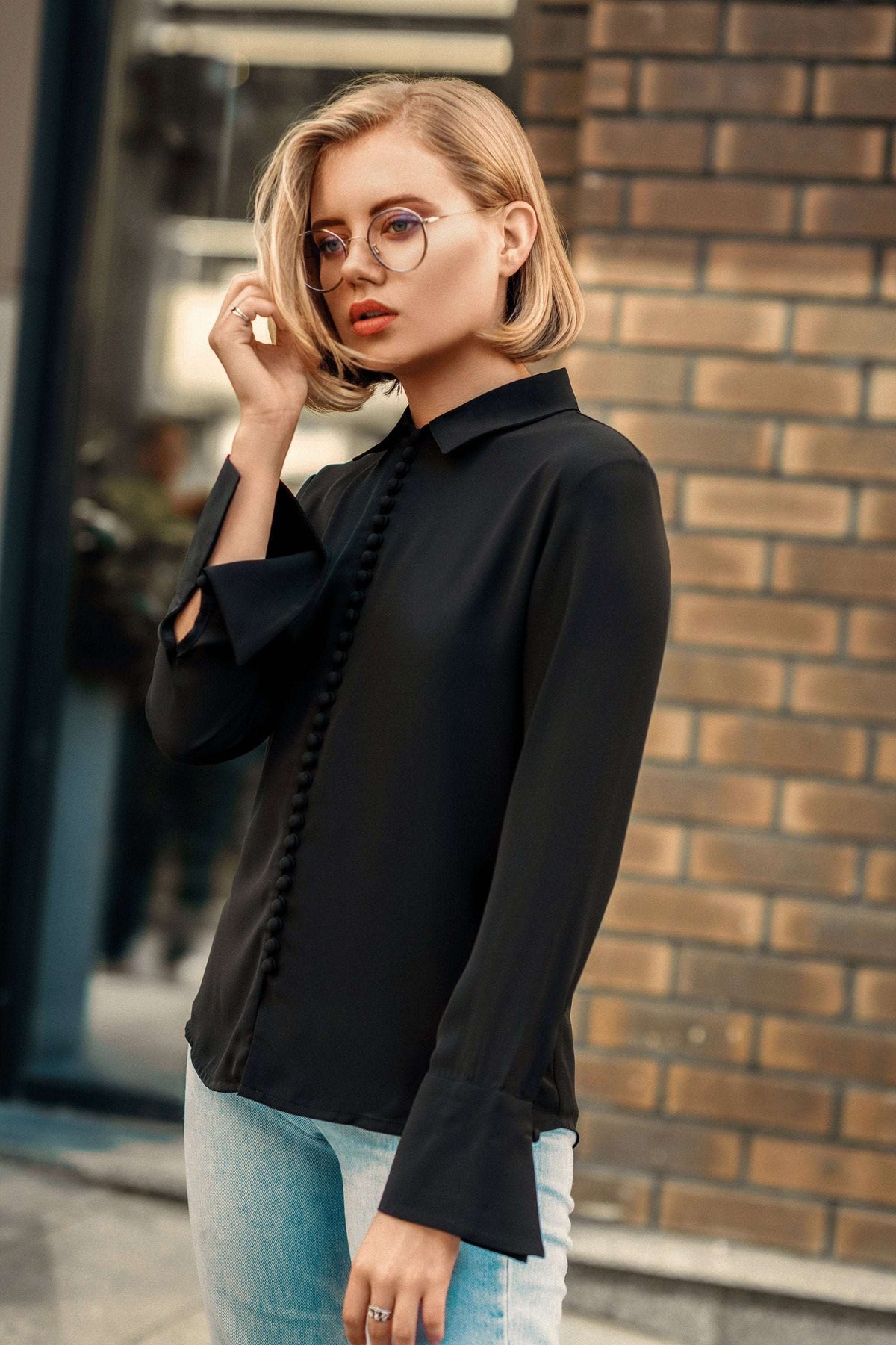 Black Bayam Blouse with button details worn by woman with glasses and blonde hair