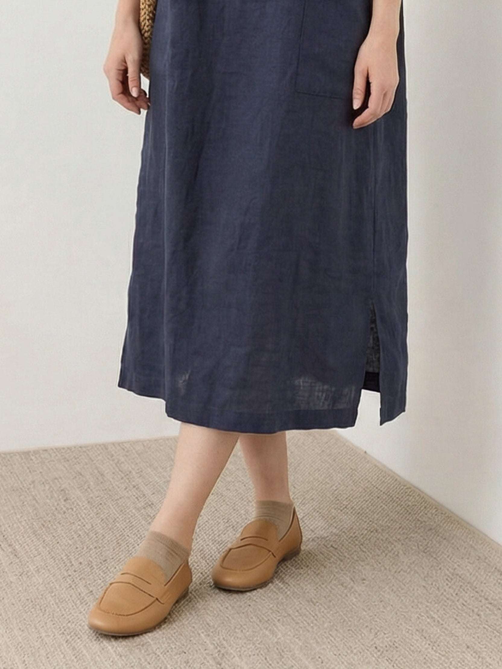 Woman wearing a 100% linen pocket midi dress with short sleeves and side slits