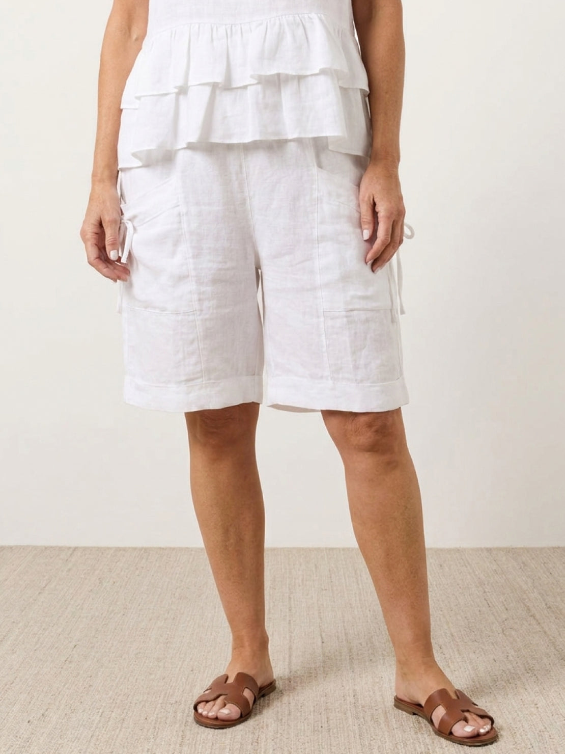 Woman wearing a cotton relaxed shorts two-piece co-ord set with ruffle detail and cuffed hem pockets