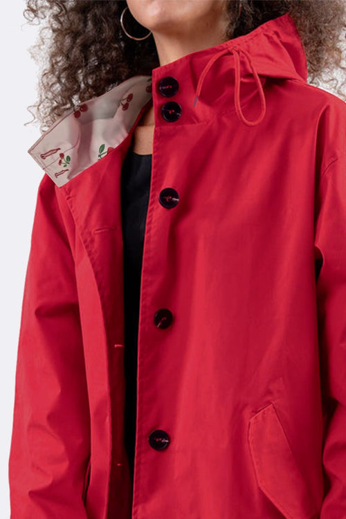 Red oversized water-resistant windbreaker jacket with hood and button closure