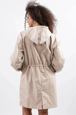 Back view of beige oversized water-resistant windbreaker with hood and adjustable waist