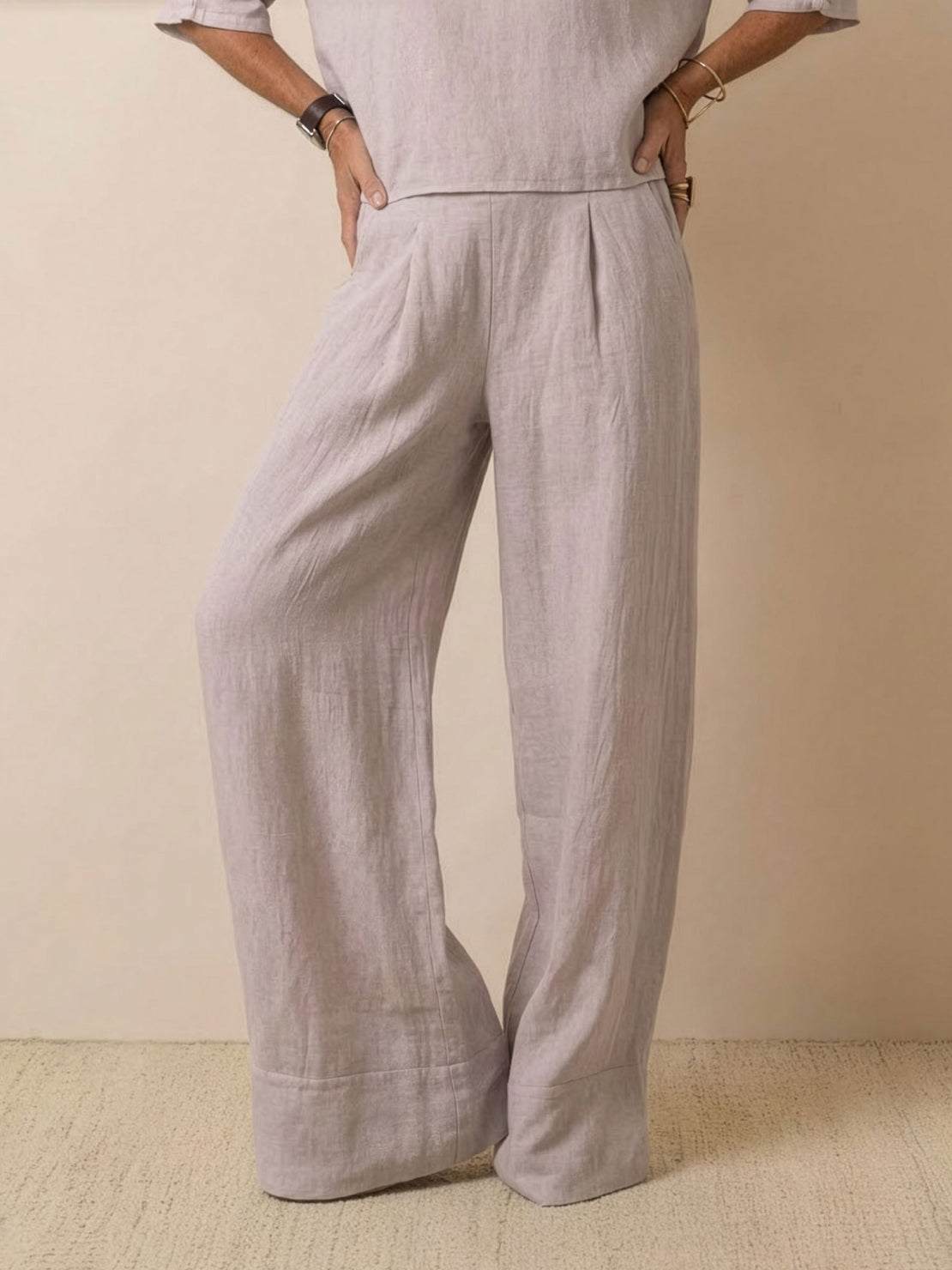 Woman wearing a beige short-sleeved pullover and wide trouser matching set with a relaxed fit and cuffed hems