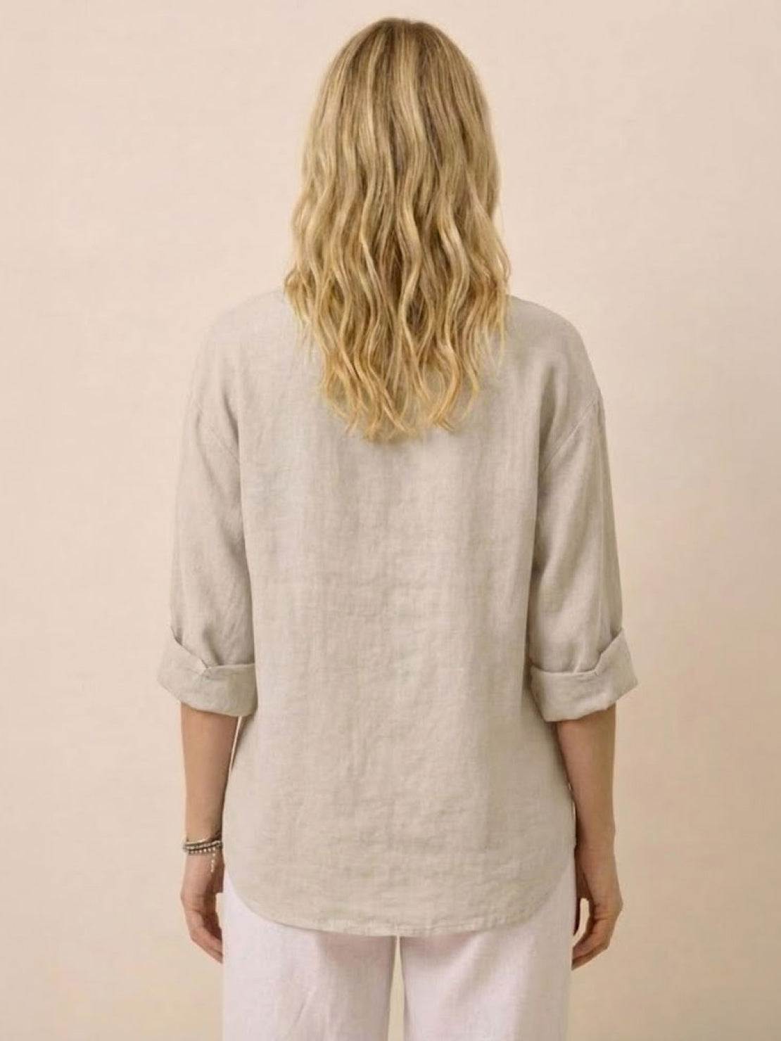 Back view of woman wearing beige pure linen age-defying button detail shirt with rolled sleeves