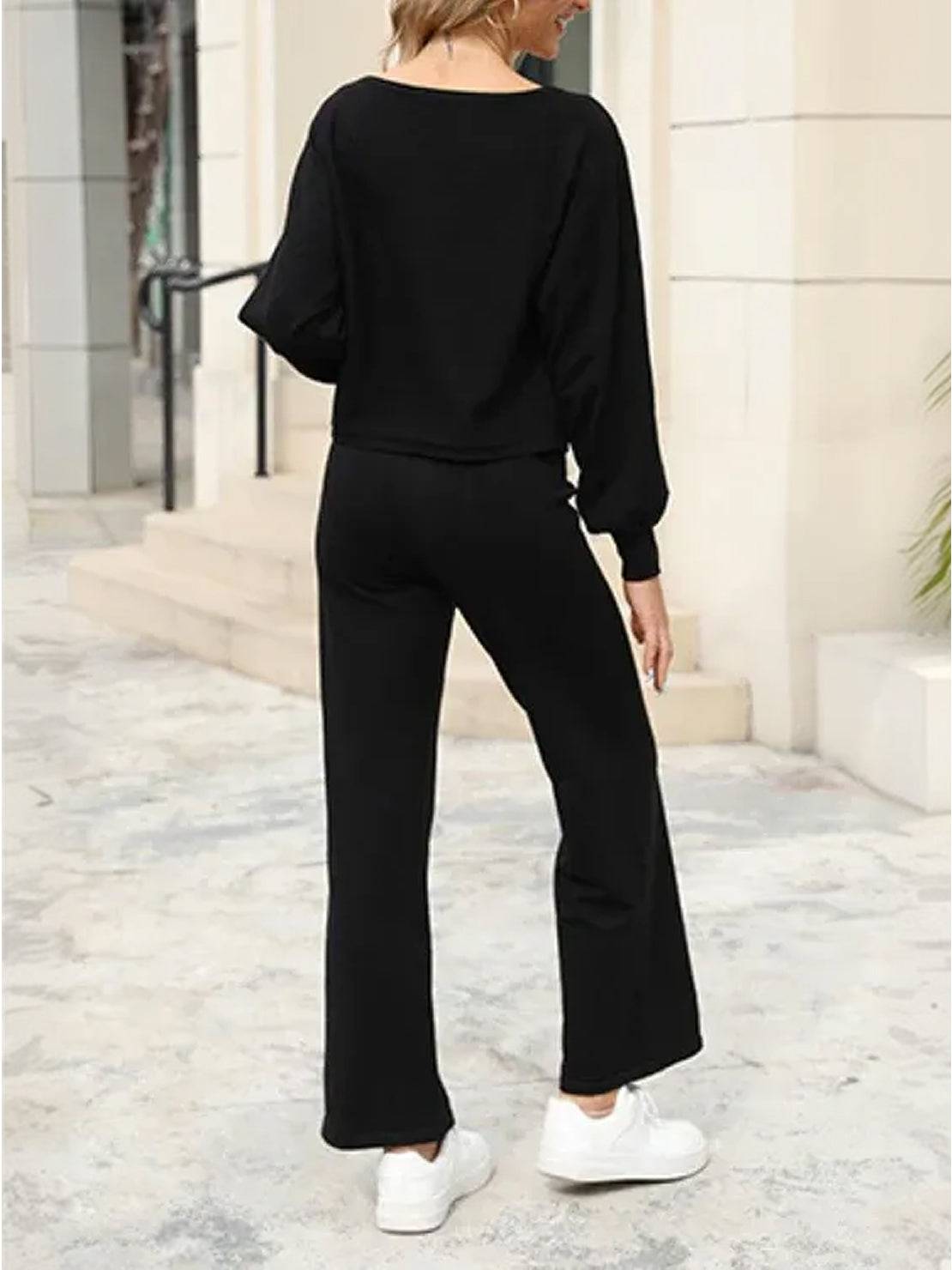 Woman wearing black round neck loose fit cozy two-piece set with wide-leg pants and white sneakers outdoors