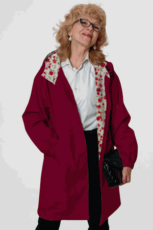 Woman wearing burgundy Rain Couture Windbreaker with floral inner lining and black purse