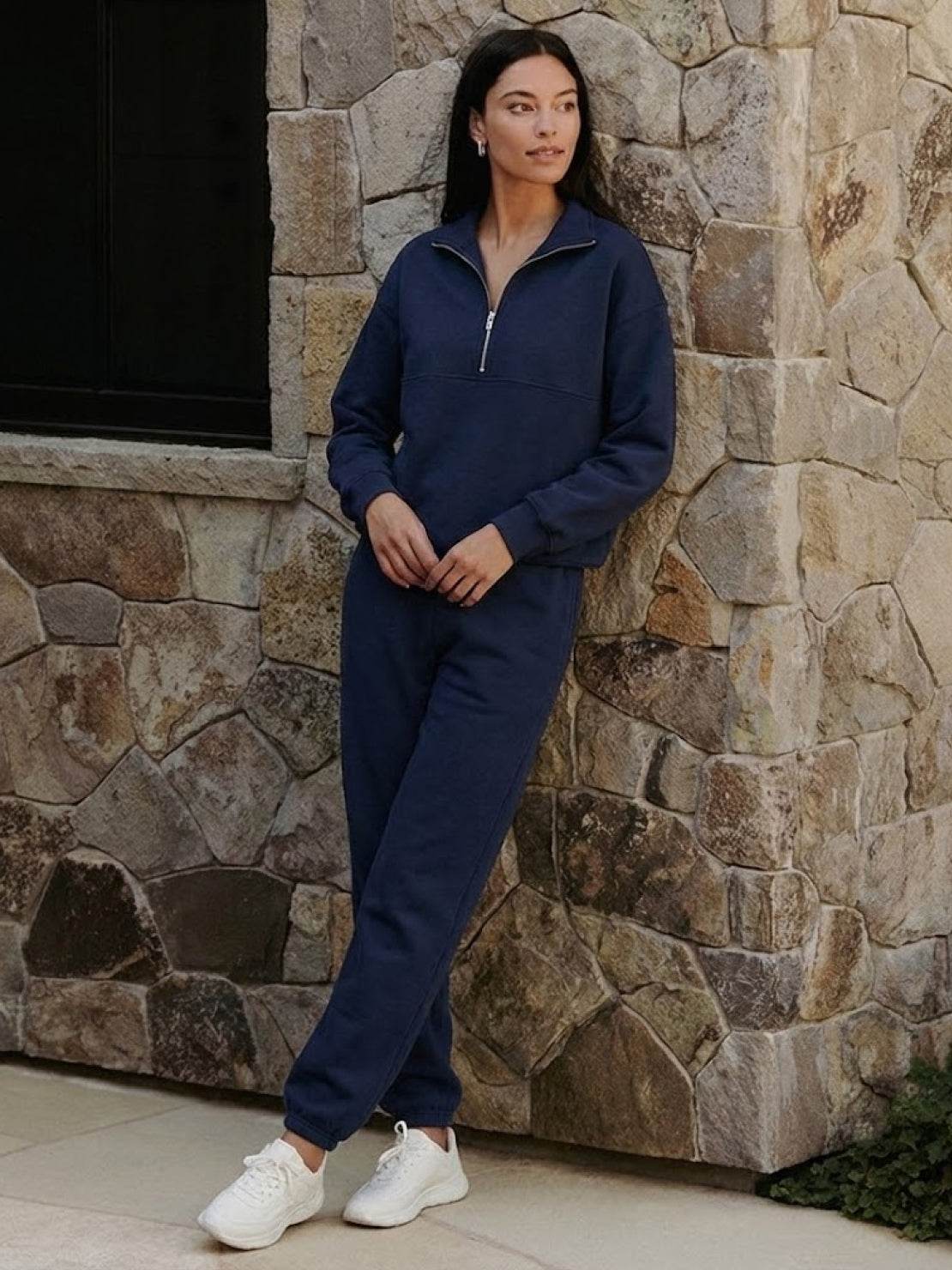 Woman wearing a cotton-blended two-piece tracksuit with high collar and deep zipper for athleisure style