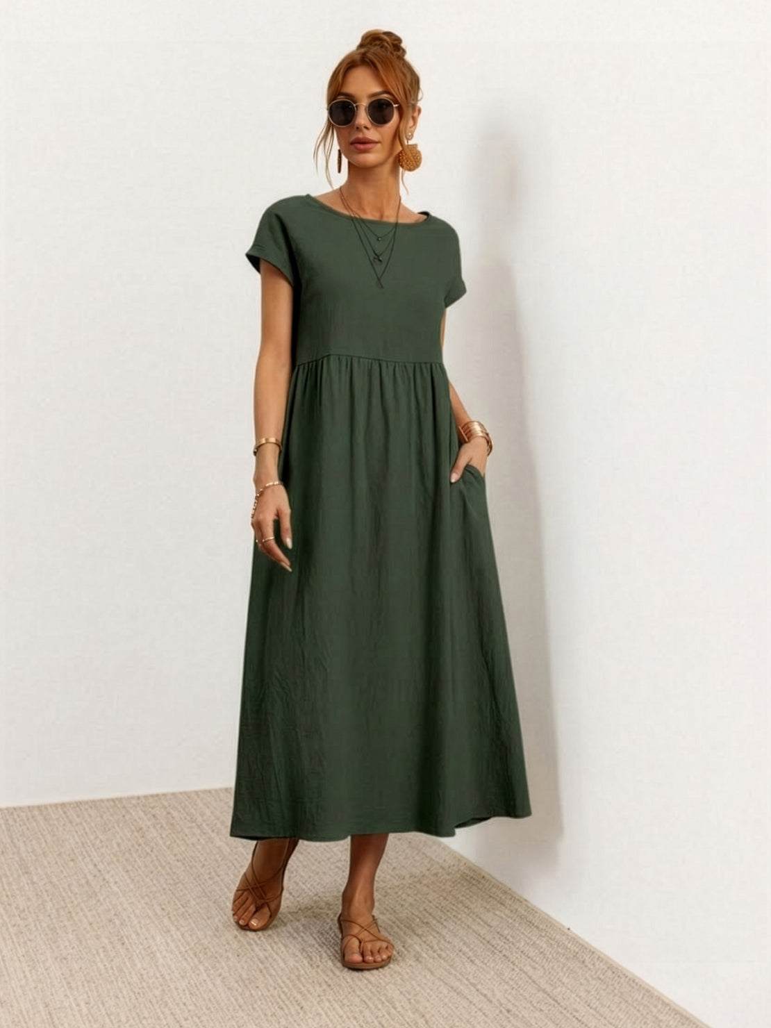 Woman wearing capped-sleeve voluminous pleated midi dress with flowing skirt and pockets