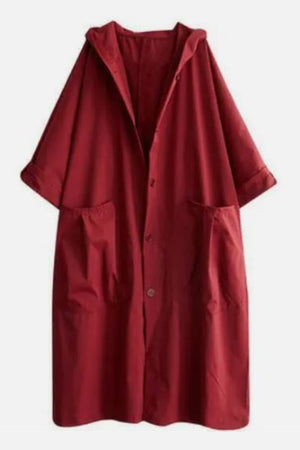 Red oversized water-resistant windbreaker jacket with hood and large front pockets, featuring a waterproof design.