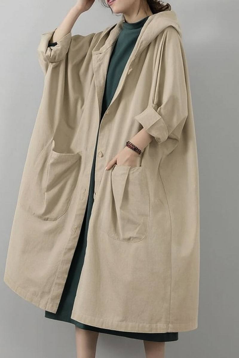 Oversized beige water resistant windbreaker jacket with hood and large front pockets for layering and protection against wind and rain