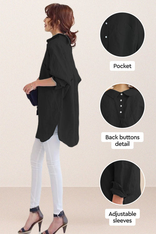 Black oversized linen shirt with back button detail, adjustable sleeves, and relaxed fit worn with white pants and heels